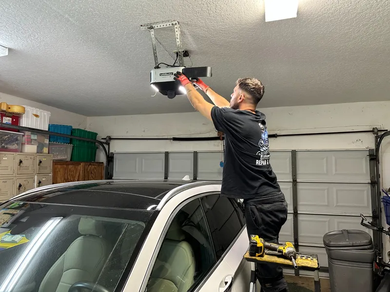 CR Garage Door Technician Repairing Overhead LiftMaster Opener Over Car